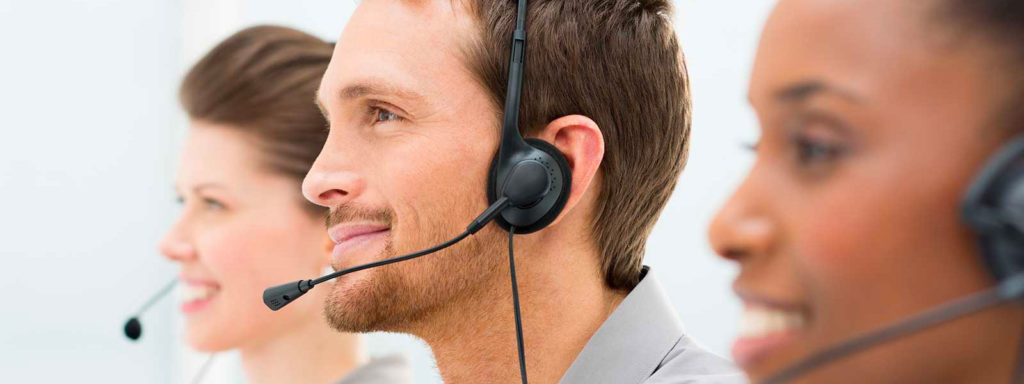 Smiling customer service workers wearing headsets.